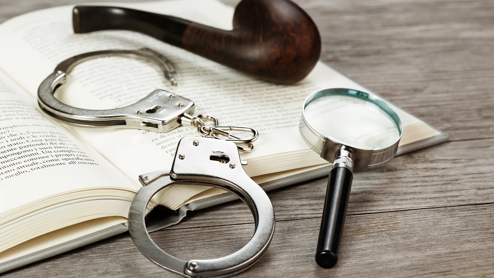 Handcuffs, a pipe, and a magnifying glass – all the tools of a murder mystery.