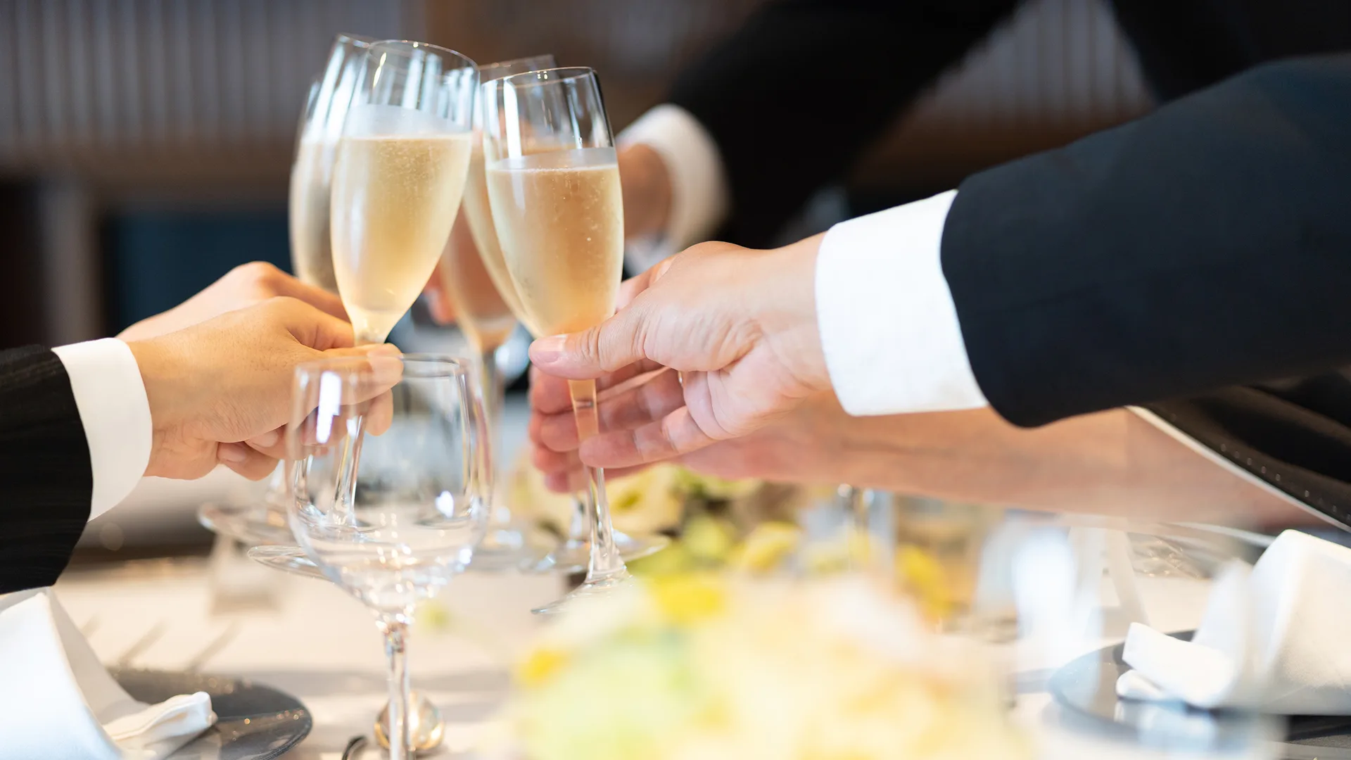 Men in suits clinking champagne glasses.