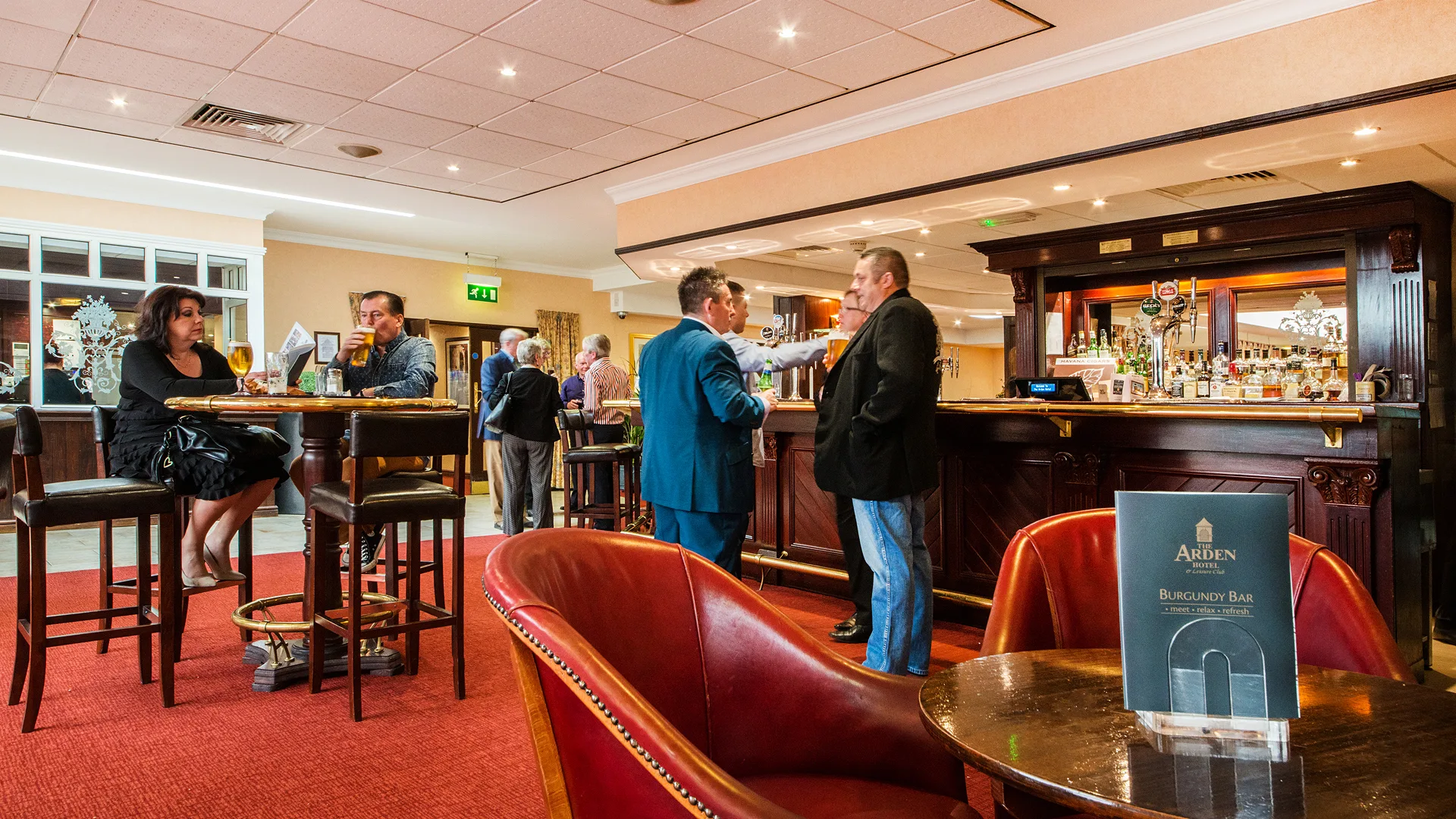 Guests chatting in the Arden Hotel’s Burgundy Bar.